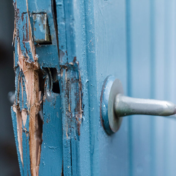 Broken door in blue and white colors after a burglery